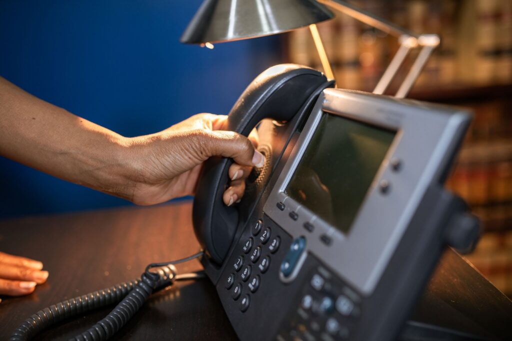 Hand lifting the handset of an office IP phone